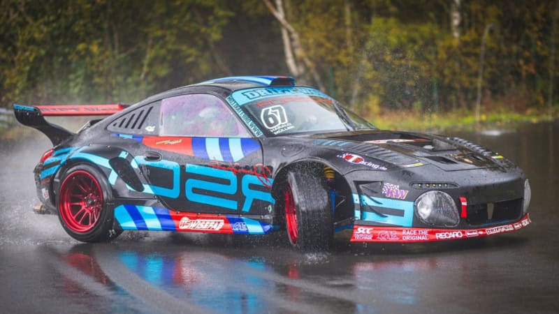 Porsche Sportauto driftet über eine nasse Rennstrecke am Nürburgring.