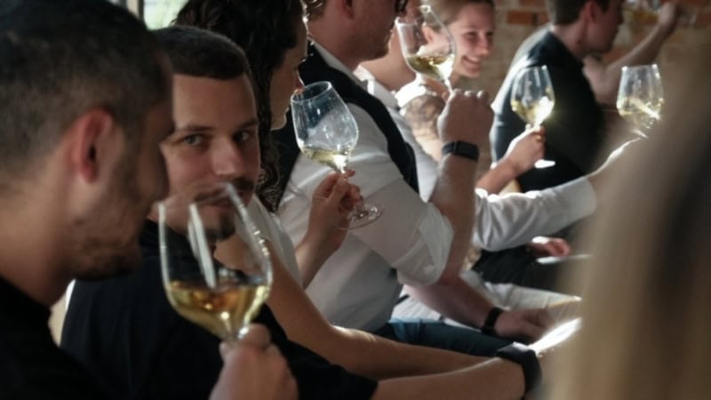 Teilnehmer der Weintasting Gameshow verkosten verschiedene Weinspezialitäten.