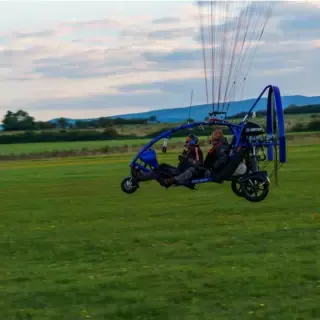 Ansicht von rechts beim Trike Drachen Rundflug, Personen sitzen drin.
