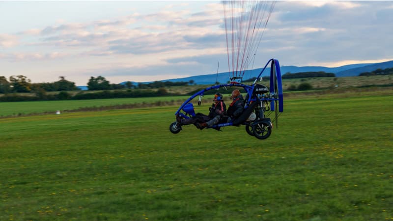 Ansicht von rechts beim Trike Drachen Rundflug, Personen sitzen drin.
