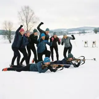 winter-gruppen-erlebnisse Eine Gruppe von neun Personen nimmt bei einem winterlichen Biathlon Erlebnis teil.