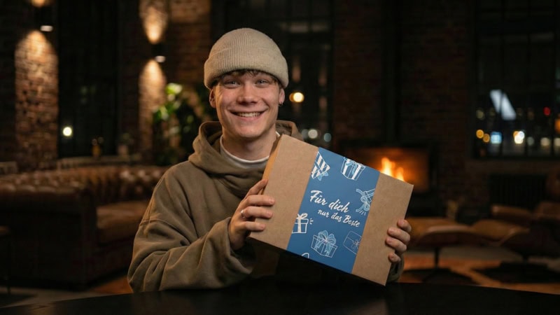 Ein Mann hält eine Geschenkbox der Erlebnisfabrik