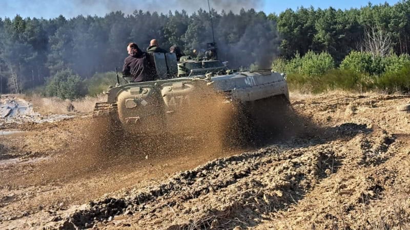 Ein Panzer der schnell durch Schlamm fährt und diesen hoch spritzen lässt.