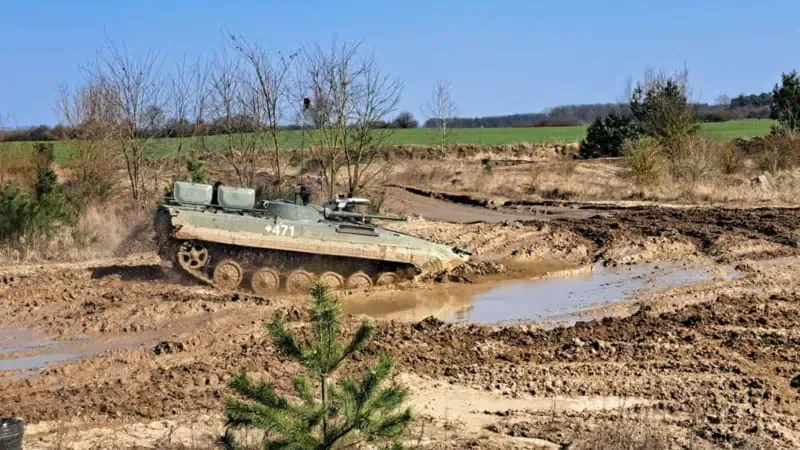 Ein Panzer der auf eine Pfütze zufährt.