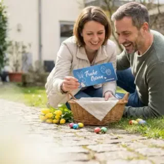 Ein Mann und eine Frau stöbern im gefundenen Osterkorb. Dabei finden sie einen Erlebnisgutschein der Erlebnisfabrik.