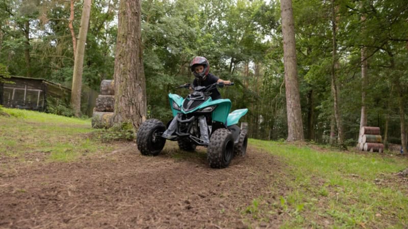 Kind driftet auf einem Quad über eine Offroad Strecke