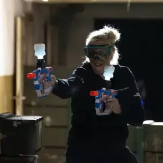 Frau mit Schutzbrille schießt mit GelBlastern