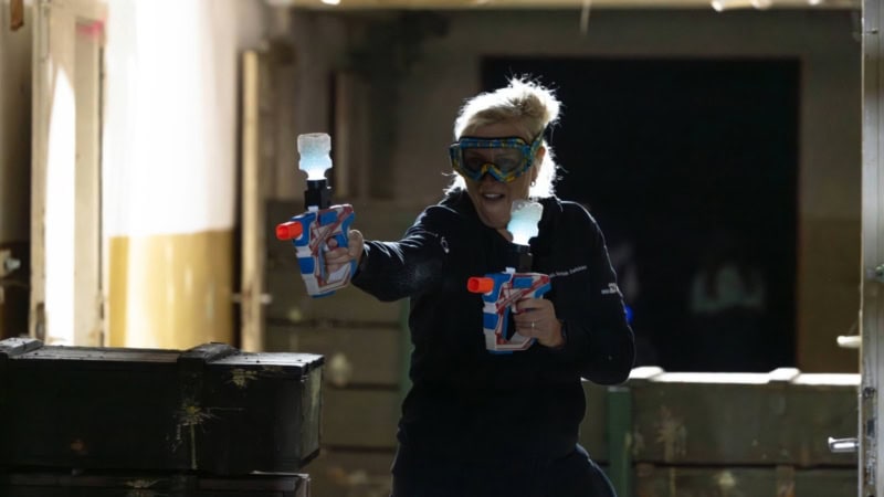 Frau mit Schutzbrille schießt mit GelBlastern