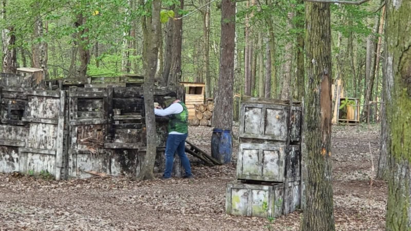 Paintballspieler hinter Deckung im Wald