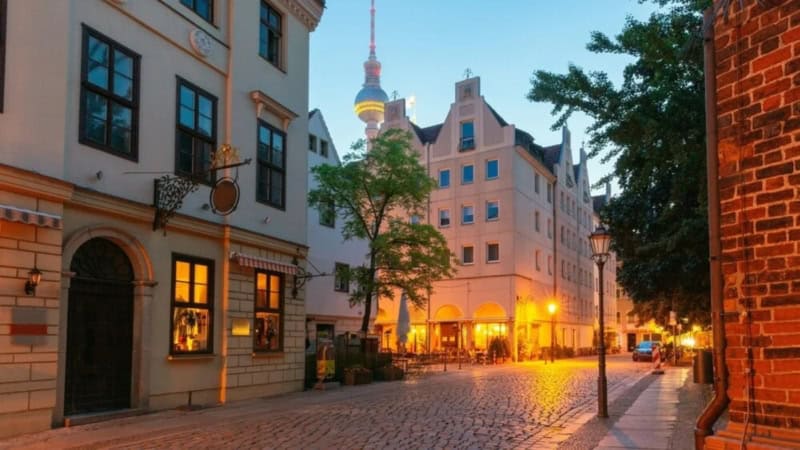 Historisches Nikolaiviertel am Abend mit Fernsehturm im Hintergrund.