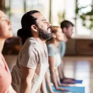 Vier Personen führen eine Yoga-Übung durch.
