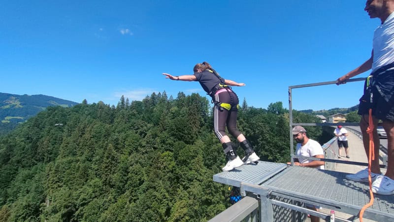 Frau Springt mit dem Bungee Seil von der Brücke