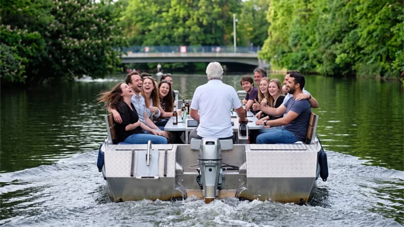 Gruppe von Menschen fährt auf einem Motorboot auf eine Brücke zu