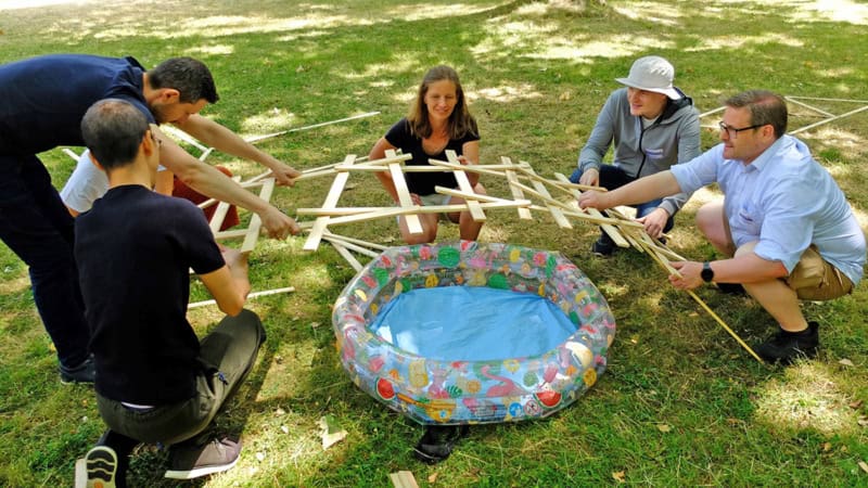 Gruppe baut eine kleine Brücke aus Holzstücken
