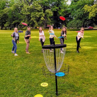 Gruppe wirft Frisbees auf ein Ziel