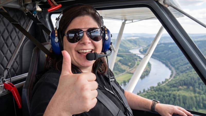 Person sitzt in einem Flugzeug bei einem Rundflug über Natur