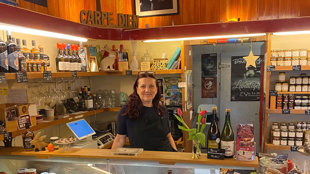 Genussroute durch Köln Frau im Cafe Mitarbeiterin hinter der Ladentheke bei einer Station der Genusstour durch Köln