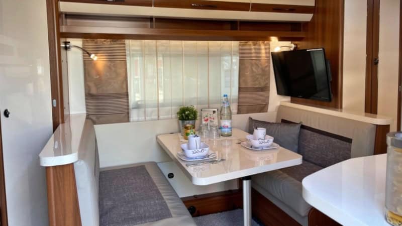 Gemütliche Sitzecke mit gedecktem Tisch im Glamping Wohnwagen auf der Alpakaweide bei Chemnitz.