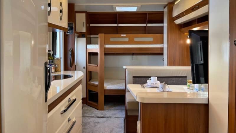 Wohnwagen Innenraum bei Glamping auf der Alpakaweide mit Sitzeckem und Etagenbett.