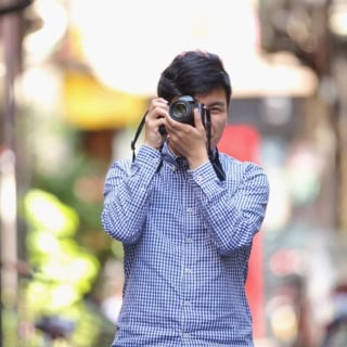 Ein Mann fotografiert bei einem Fotokurs.