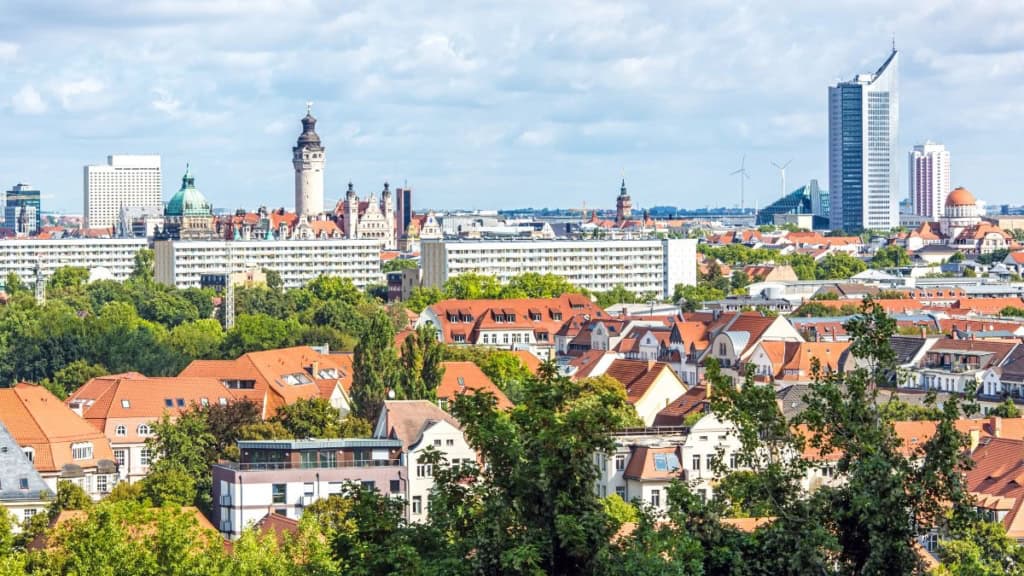 Erlebnisfabrik Stadtansicht Blick auf historische und moderne Gebäude von Leipzig, grüne Parks und Wolkenkratzer im Hintergrund.