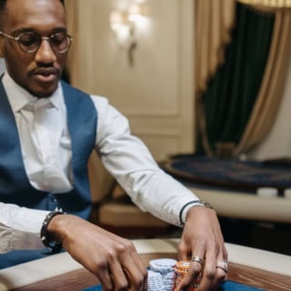 Ein Spieler setzt Spielchips bei einem Pokerspiel während eines Pokerkurses.
