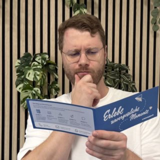 blog-gutschein-personalisieren Ein Mitarbeiter der Erlebnisfabrik hält einen Gutschein in der Hand.